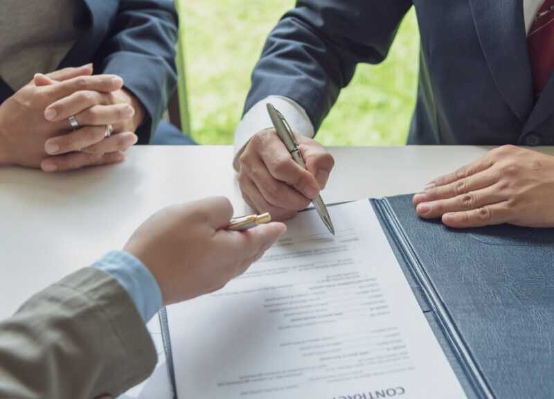 Signing Contracts. A group of business people sign a joint investment contract HFG Trust
