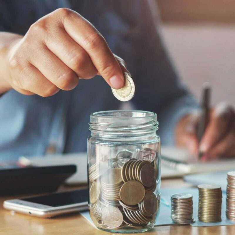 man putting money in a jar save for retirement HFG Trust