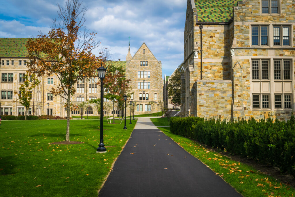 College campus walkway lined with stone Gothic buildings and autumn trees, illustrating college tax credits and 529 planning