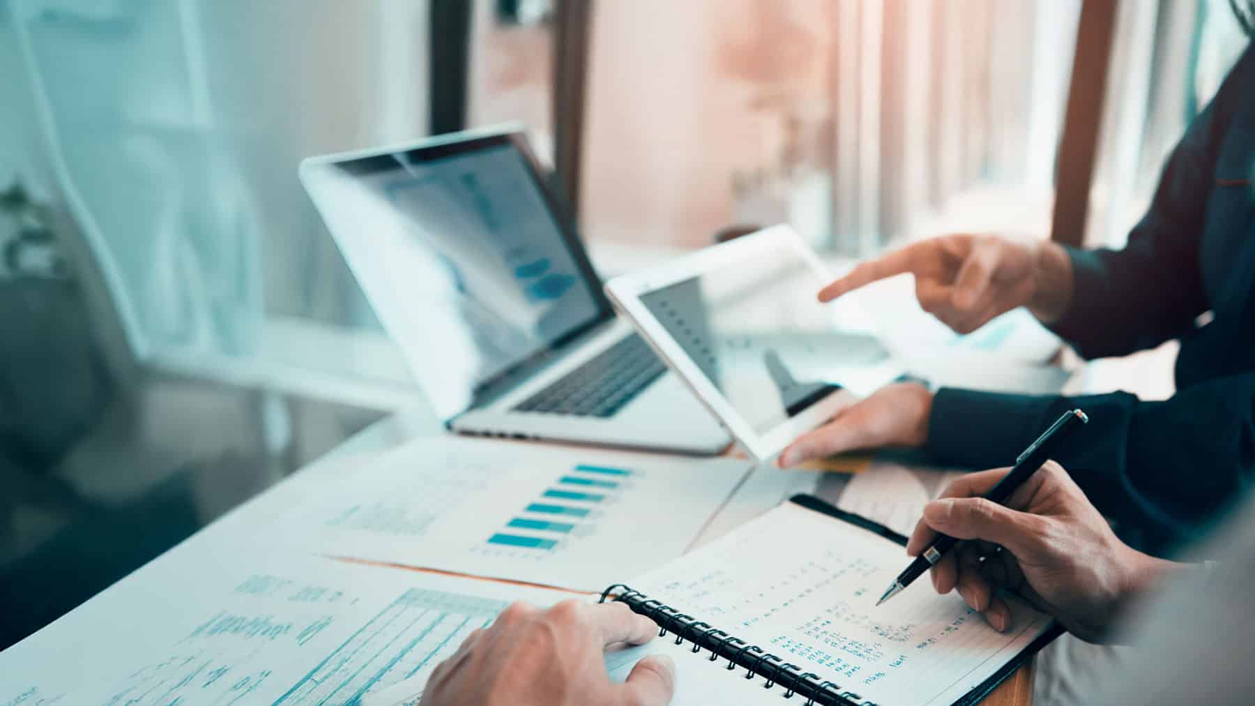 Wealth advisors analyzing charts and data on investments during a portfolio management strategy session at HFG Trust in Kennewick, Washington