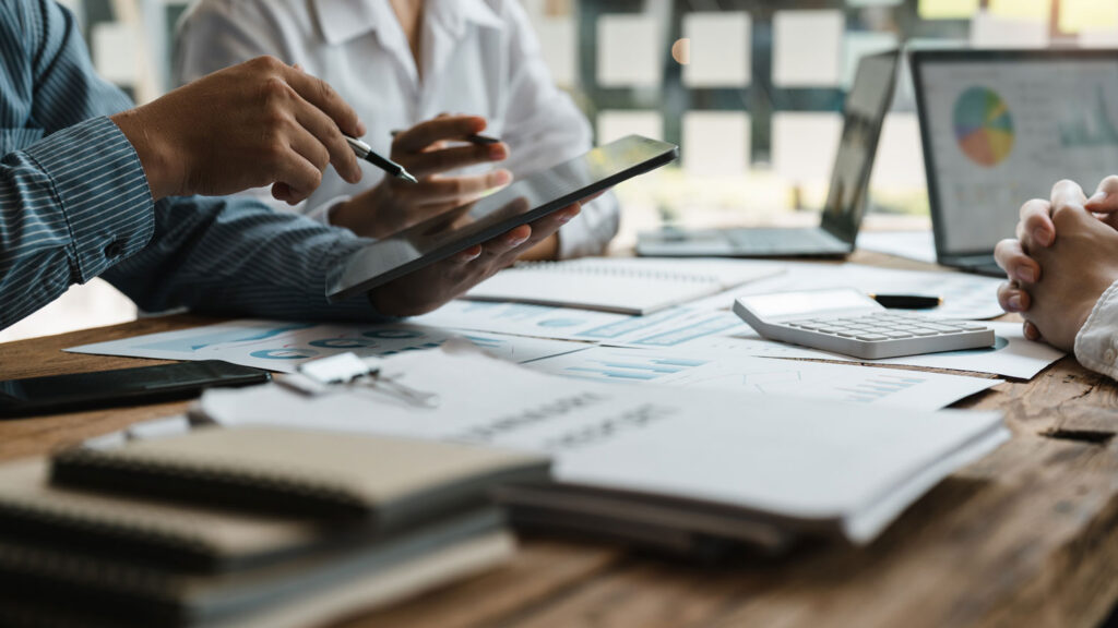 Tax planning and portfolio management review with a fiduciary advisor, analyzing charts and reports