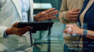 Ongoing financial planning check-in with a fiduciary advisor, reviewing strategy on a tablet