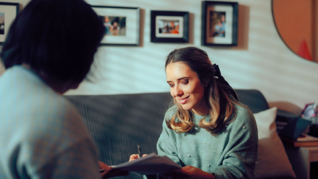Woman signing power of attorney paperwork during an estate planning meeting with financial advisor